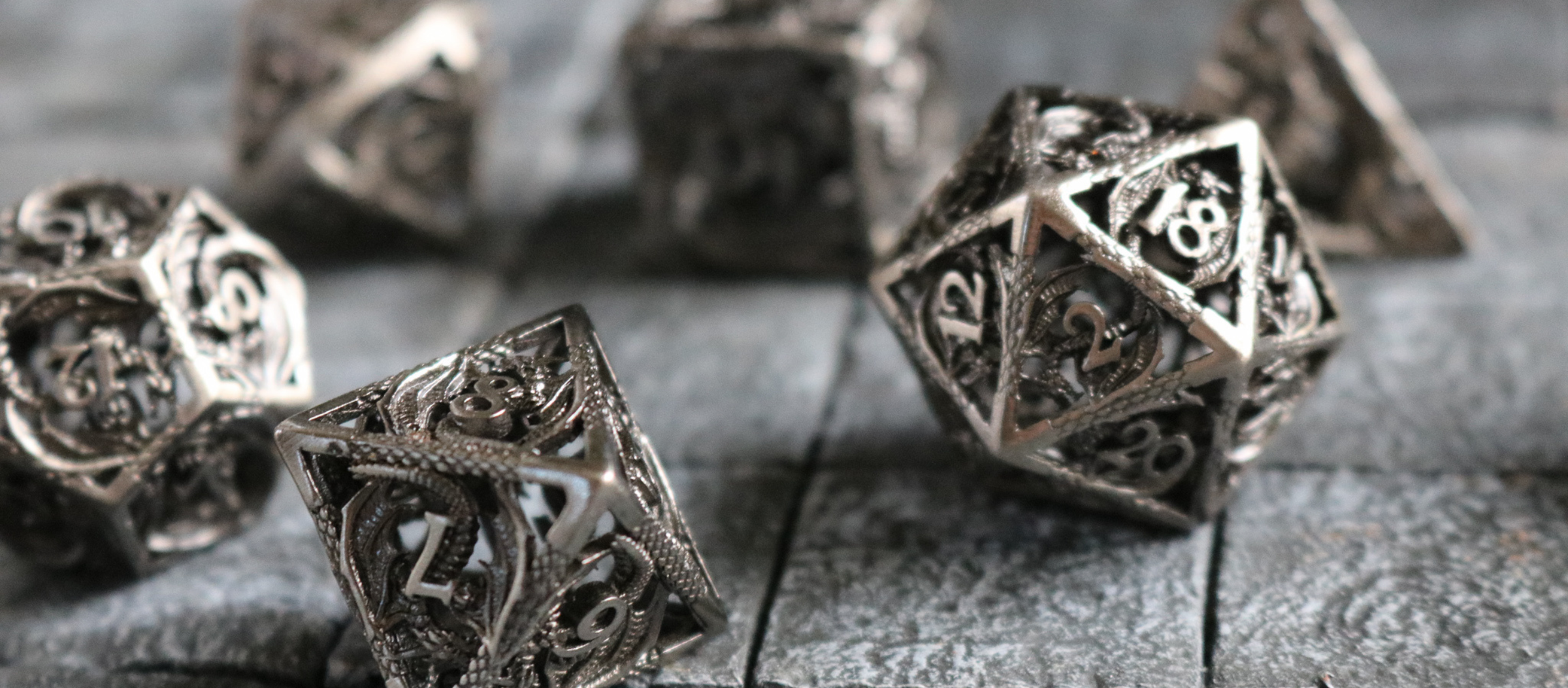 Intricately designed metal DnD dice sets, showcasing powerful designs like dragons, skulls, and shields for precise rolls.